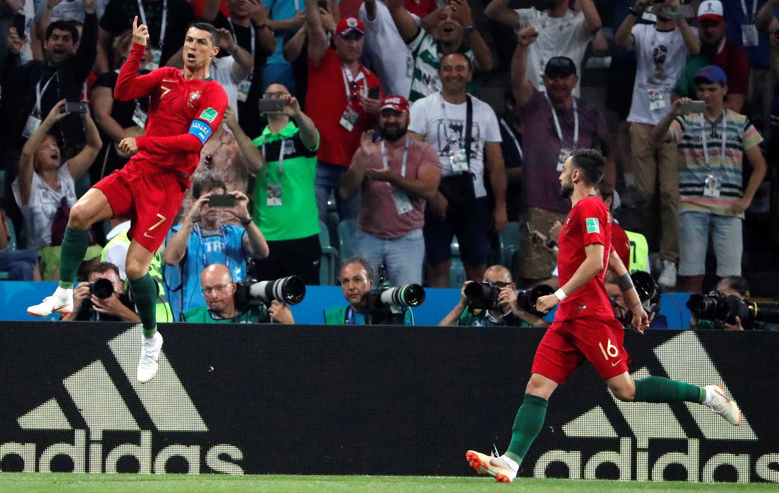 epa06811056 Portuguese forward Cristiano Ronaldo (L) celebrates after scoring by pemalty kick during the FIFA World Cup 2018 Group B soccer match between Portugal and Spain, in Sochi, Russia, 15 June  ...