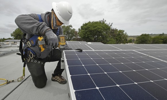 Gen Nashimoto, of Luminalt, installs solar panels in Hayward, Calif., on Wednesday, April 29, 2020. From New York to California, the U.S renewable energy industry is reeling from the new coronavirus p ...