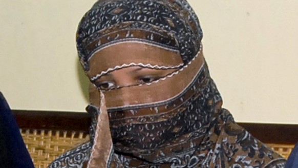 FILE - In this Nov. 20, 2010, file photo, Asia Bibi, a Pakistani Christian woman, listens to officials at a prison in Sheikhupura near Lahore, Pakistan. Italy is working to help relocate the family of ...
