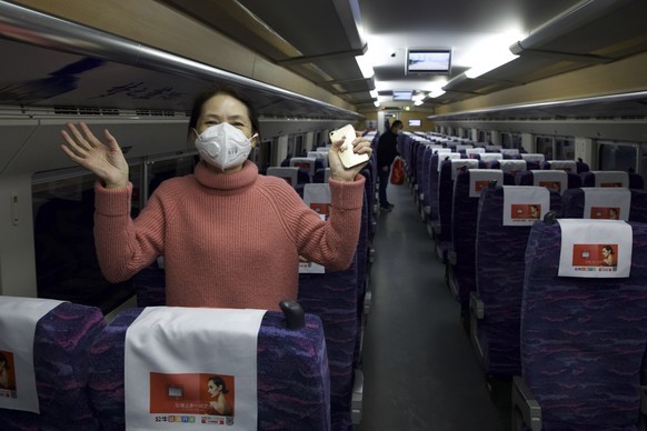 A passenger wearing a face mask to protect against the spread of new coronavirus talks about how happy she is to leave her 76-day stay in lockdown in Wuhan as she boards the first high-speed train to  ...