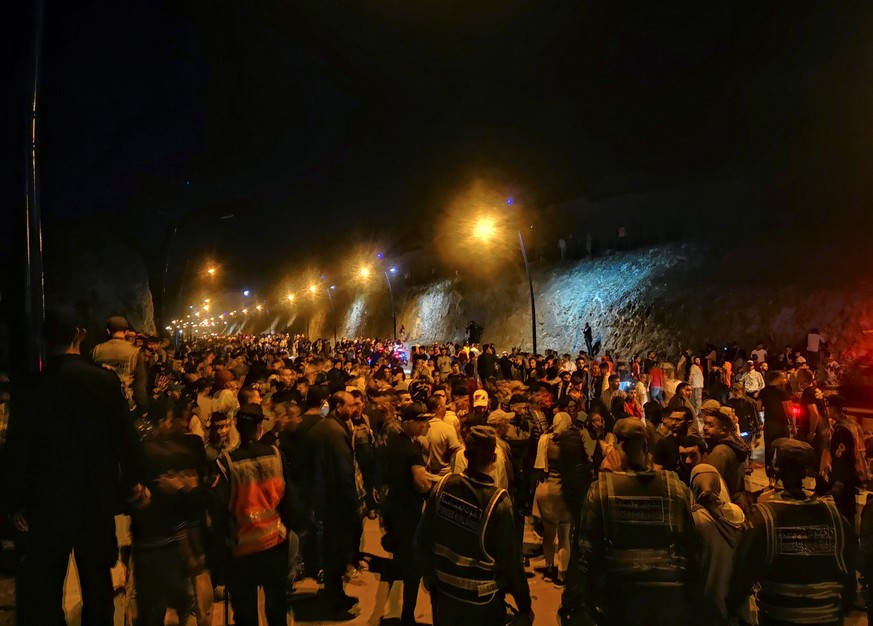 epa09207747 Hundreds of young Moroccans wait to cross the border with Spain in the town of Castillejos, also known as Fnideq, Morocco, 17 May 2021. The Spanish Government Delegation in Ceuta has repor ...