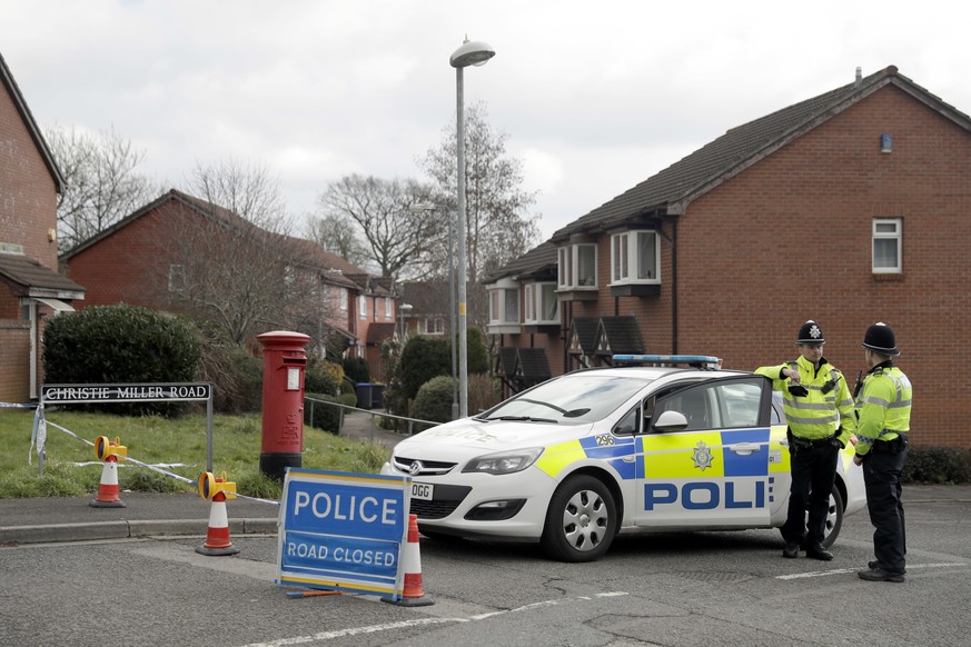 Police officers stand guard at the bottom of the road where former Russian double agent Sergei Skripal lives in Salisbury, England, Tuesday, March 13, 2018. The use of Russian-developed nerve agent No ...