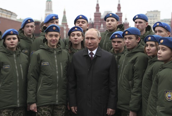 Russian President Vladimir Putin poses for a picture with members of youth organizations during a flower-laying ceremony at the Monument to Minin and Pozharsky at Red Square, during National Unity Day ...