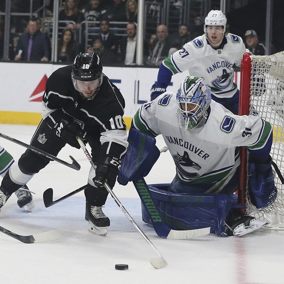 Vancouver Canucks goalie Anders Nilsson (31) and Los Angeles Kings center Tobias Rieder (11) and others battle at the goal in the second period of an NHL hockey game in Los Angeles, Monday, March 12,  ...