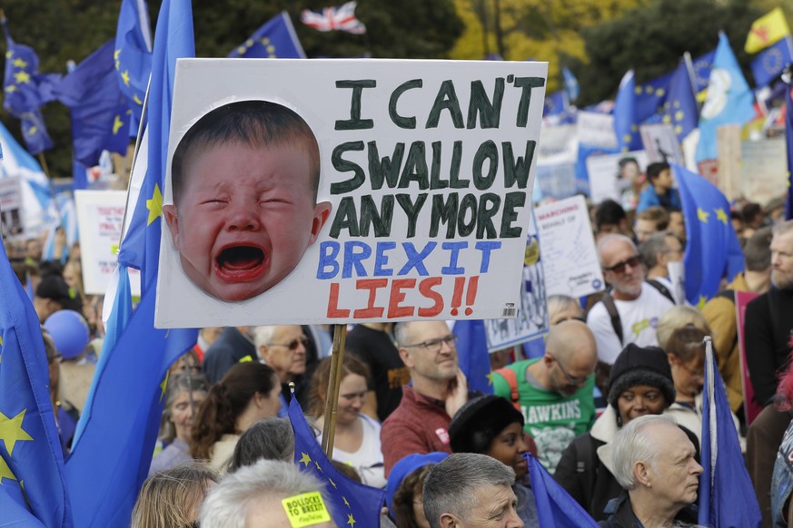 Anti-Brexit demonstrators carry placards and EU flags in London, Saturday, Oct. 19, 2019. In their first weekend session in 37 years, British lawmakers in Parliament debated whether to accept Prime Mi ...