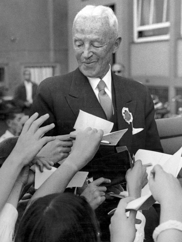 Henri Guisan, ehemaliger General der Schweizer Armee im Zweiten Weltkrieg, verteilt Autogramme an Jugendliche, undatierte Aufnahme Ende der 1950er Jahre. (KEYSTONE/Hans-Ueli Bloechliger)