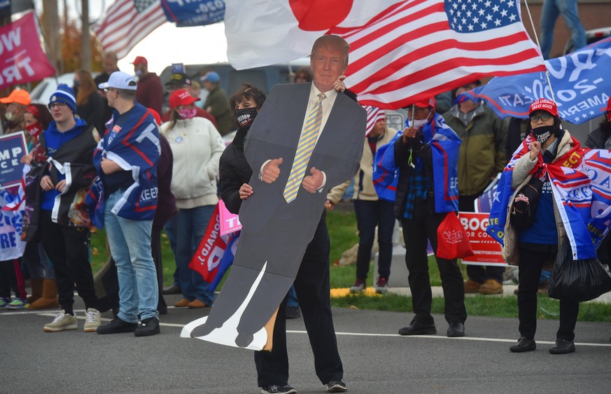 October 24, 2020, Dallas, United States: A woman dances on Memorial highway with a cardboard Donald Trump while a Trump support rally while waiting for Joe Biden to pass on his way to a rally in Dalla ...