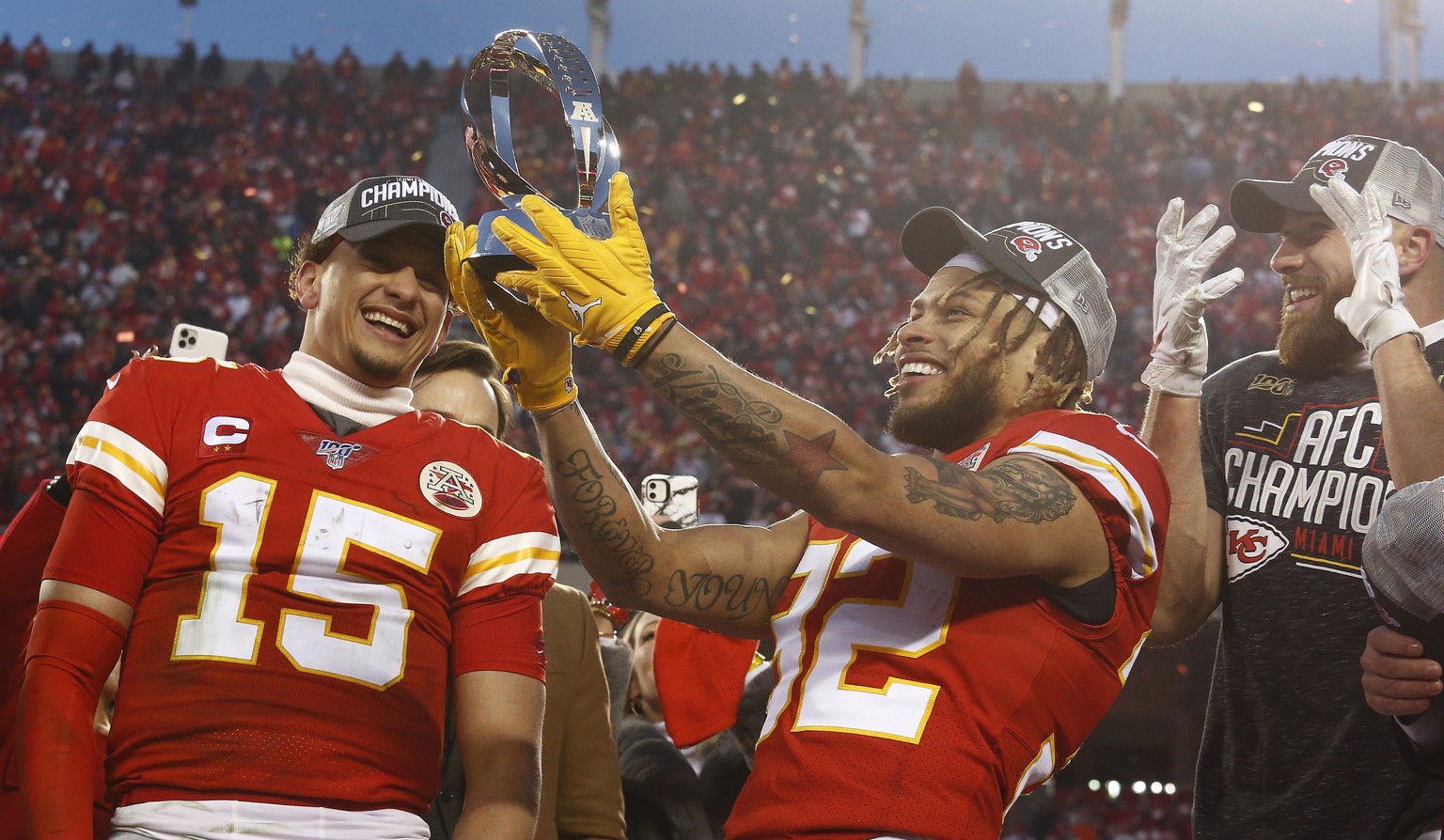 epaselect epa08142615 Kansas City Chiefs quarterback Patrick Mahomes (L) Tyrann Mathieu (C) and Travis Kelce (R) looks at the Lamar Hunt Trophy on stage after beating the Tennessee Titans in their AFC ...
