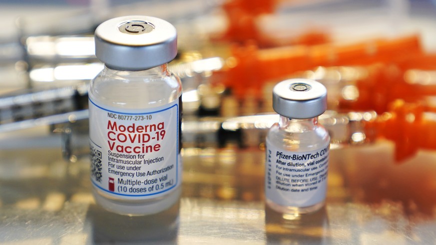 Vials for the Moderna and Pfizer COVID-19 vaccines are displayed on a tray at a clinic set up by the New Hampshire National Guard in the parking lot of Exeter, N.H., High School, Thursday, Feb. 25, 20 ...