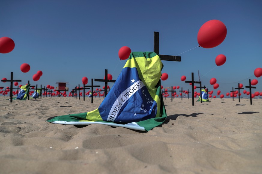 epa08592304 An installation of red ballons and crosses honoring victims of the coronavirus pandemic in Brazil, at Copacabana beach in Rio de Janeiro, Brazil, 08 August 2020. Brazil is the second most  ...