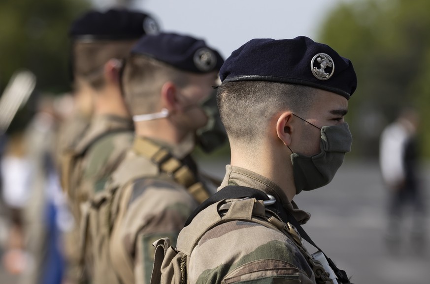 epa08408293 French soldiers wearing protective face masks stand to attention lining the street as they await the hearses carrying French soldiers brigadier-chief Dmytro Martynyouk and brigadier Kevin  ...