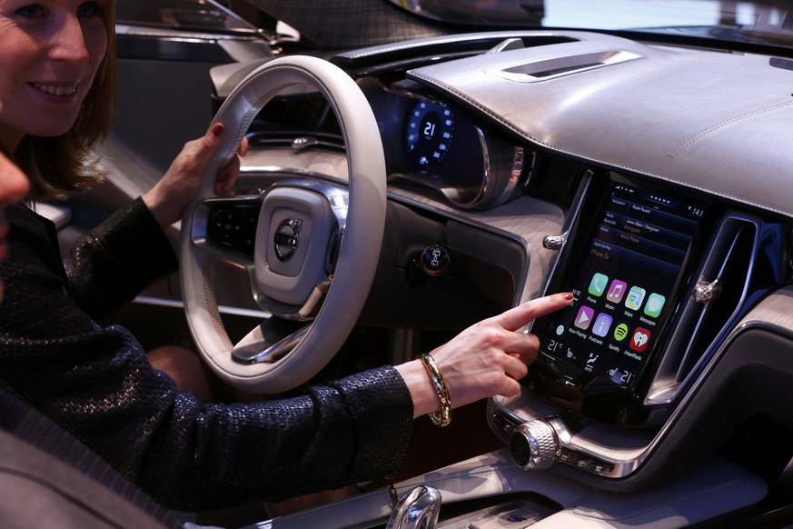 A woman touches the display inside a Volvo car during the media day ahead of the 84th Geneva Motor Show at the Palexpo Arena in Geneva March 4, 2014. Apple makes its next move in hands-free smartphone ...