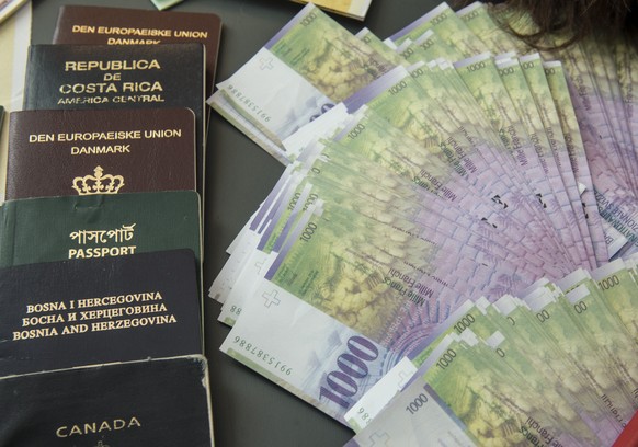 Beschlagnahmte gefaelschte Paesse und Banknoten werden praesentiert an der Jahres-MK des Grenzwachtkorps am Dienstag, 18. Februar 2014, in Chiasso. (KEYSTONE/Karl Mathis)