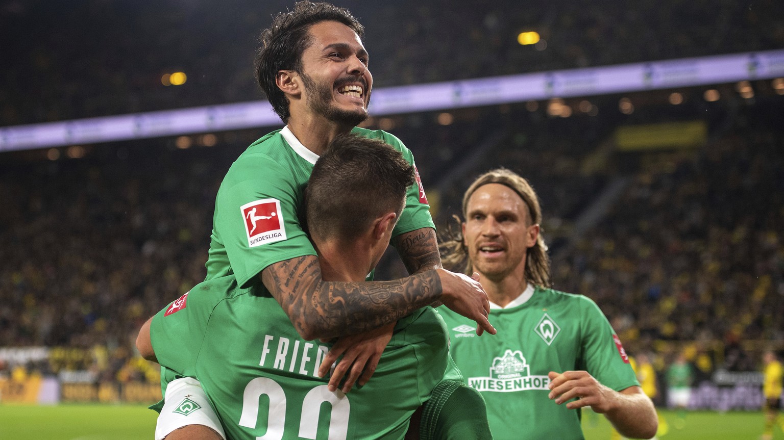 Bremen&#039;s Leonardo Bittencourt, left to right, Torsch&#039;tze Marco Friedl and Michael Lang jubilate bringing the score to 2:2, in action during their 6th round Bundesliga soccer match Borussia D ...