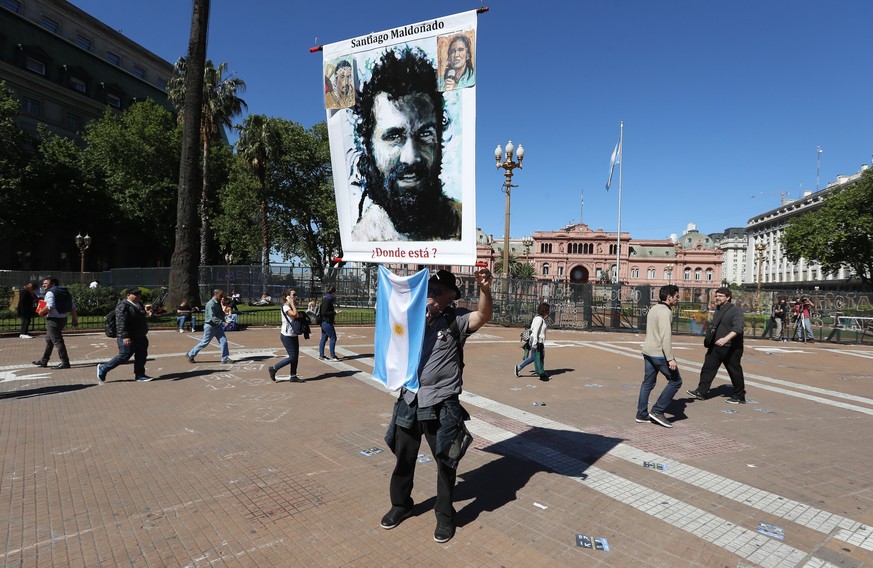 epa06277286 A person carries a poster with the image of the missing Santiago Maldonado during the protest of the Mothers of Plaza Mayo to seek justice for the case of the missing Santiago Maldonado in ...