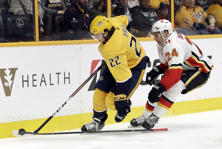Calgary Flames defenseman Travis Hamonic (24) loses his stick as he follows Nashville Predators left wing Kevin Fiala (22), of Switzerland, in the second period of an NHL hockey game Tuesday, Oct. 24, ...