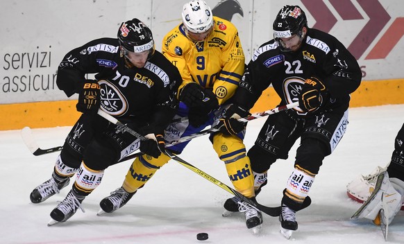 Lugano&#039;s player Matteo Romanenghi, Davos&#039;s player Tino Kessler and Lugano&#039;s player Stefan Ulmer, from left, fight for the puck, during the preliminary round game of National League Swis ...