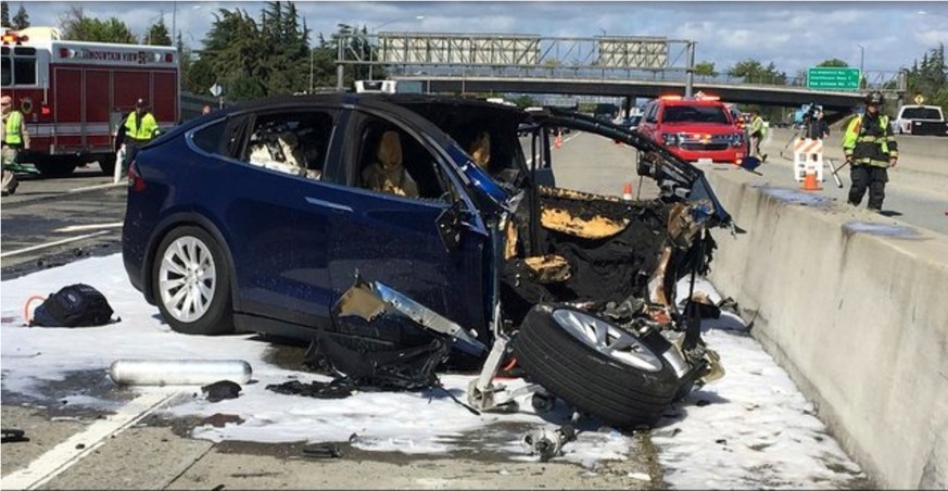 FILE - In this March 23, 2018 file photo provided by KTVU, emergency personnel work a the scene where a Tesla electric SUV crashed into a barrier on U.S. Highway 101 in Mountain View, Calif. Tesla say ...