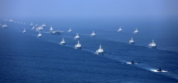 FILE - In this April 12, 2018, file photo released by Xinhua News Agency, the Liaoning aircraft carrier is accompanied by navy frigates and submarines conducting an exercises in the South China Sea. C ...
