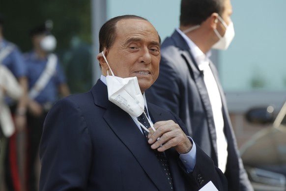 FILE - In this Sept. 14, 2020 file photo, Italian former Premier Silvio Berlusconi adjusts his face mask as he leaves the San Raffaele hospital after testing positive for COVID-19, in Milan, Italy. Be ...