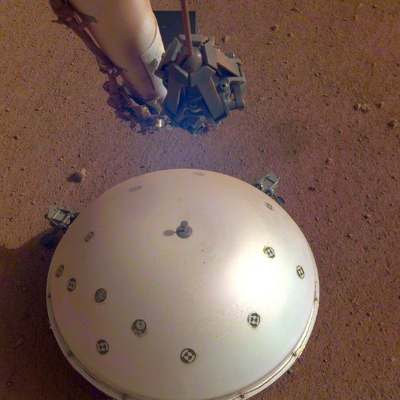 This photo made available by NASA on Tuesday, April 23, 2019 shows the InSight lander&#039;s domed wind and thermal shield which covers a seismometer on the 110th Martian day, or sol, of the mission.  ...