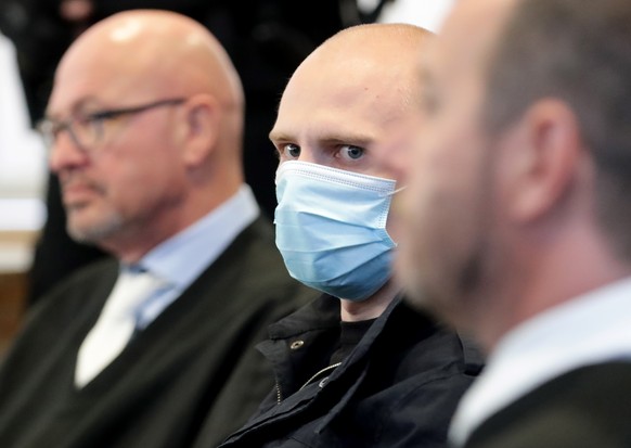 epaselect epa08558176 Defendant Stephan Balliet (C) sits between his lawyers Hans-Dieter Weber (L) and Thomas Rutkowski (R) at the beginning of the main trial of the terror attack in Halle at regional ...