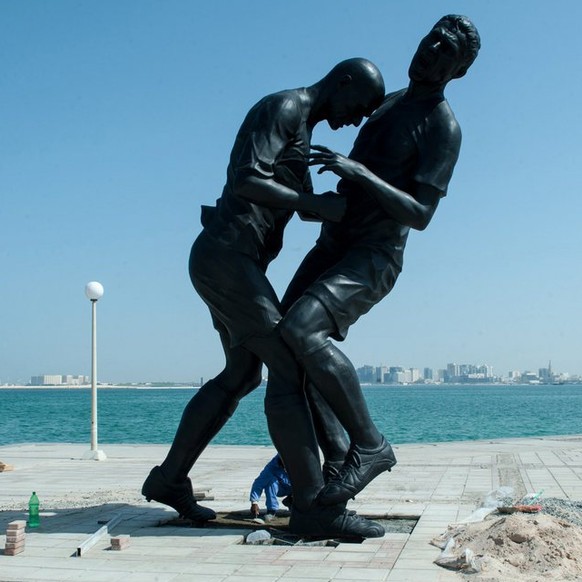 epa03895867 Workers install a five-meter-tall bronze statue of former French soccer international Zinedine Zidane&#039;s famous head-butt at the corniche of Doha, Qatar, 04 October 2013. The sculpture ...