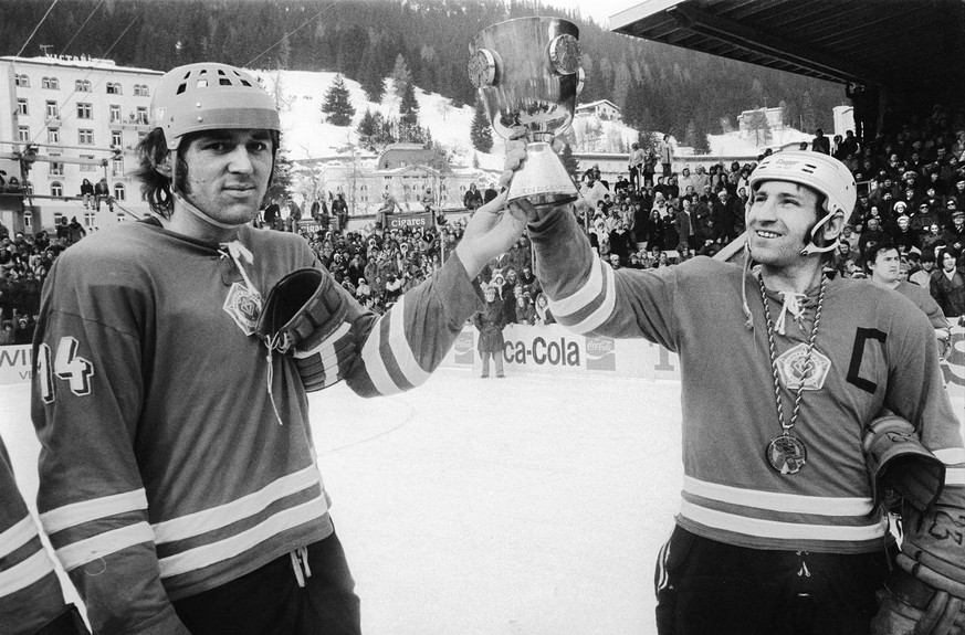 Vaclav Nedomanski (Nr. 14) und Milan Mrukvia, Captain von Slovan Bratislava (CZECH) triumphieren mit dem Siegerpokal des Spengler Cup in Davos, aufgenommen am 31. Dezember 1973. Slovan Bratislava gewi ...