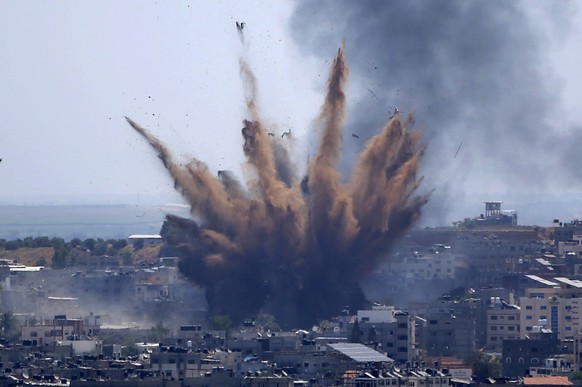 Smoke rises following Israeli airstrikes on a building in Gaza City, Thursday, May 13, 2021. Weary Palestinians are somberly marking the end of the Muslim holy month of Ramadan, as Hamas and Israel tr ...