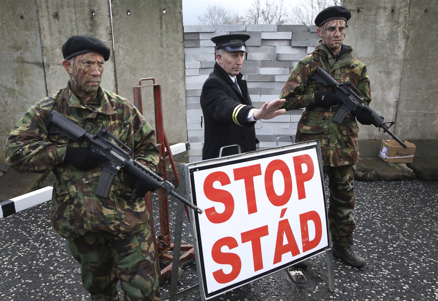 Demonstrators hold banners on the Northern Ireland/Republic of Ireland border, near Newry in Northern Ireland, Saturday, Jan. 26, 2019. Protesters angered at the prospect of a hard Brexit built a mock ...