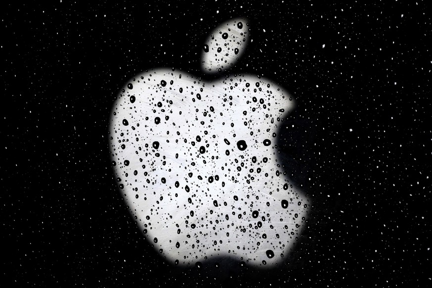 FILE - In this Dec. 26, 2018, file photo, an Apple logo is seen in raindrops on a window outside an Apple Store at the Country Club Plaza shopping district in Kansas City, Mo. The U.S. Justice Departm ...