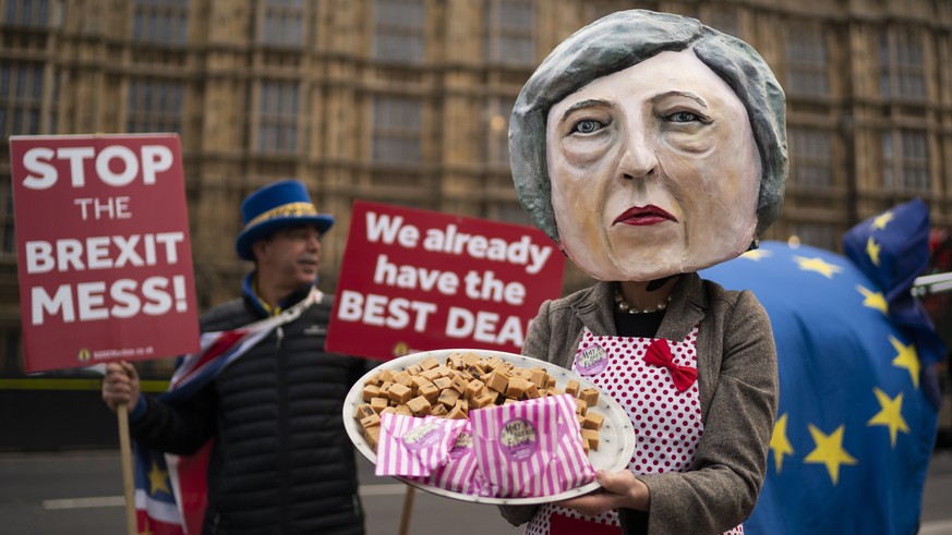 epa07221280 Anti-Brexit campaigner dressed as British Prime Minister Theresa May holding a plate of fudge poses for photographers outside Houses of Parliament in Central London, Britain, 10 December 2 ...