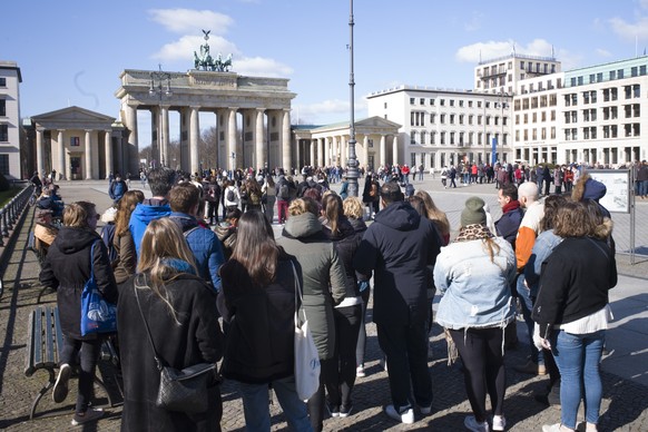 Tourist crowd around a guide in front of the in Berlin, Germany, Saturday, March 14, 2020. Germany has been slower than some of its neighbours to ban large gatherings, initially leaving the decision t ...