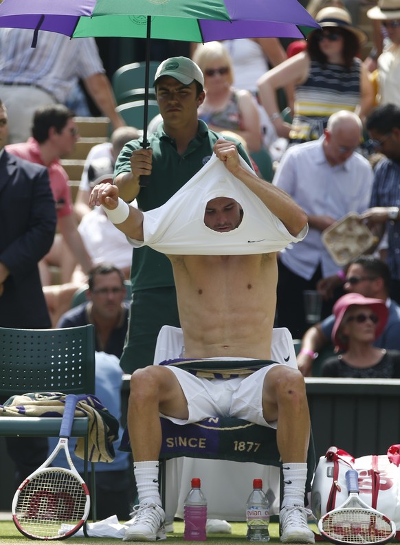 Grigor Dimitrov of Bulgaria changes his shirt during a game break in his men&#039;s singles quarterfinal match against Andy Murray of Britain at the All England Lawn Tennis Championships in Wimbledon, ...