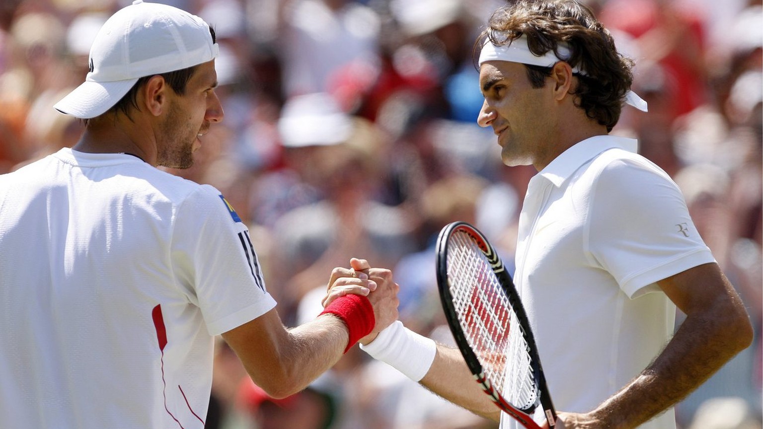 epa02227830 Roger Federer of Switzerland (R) at the net with Juergen Melzer of Austria whom he defeated in their fourth round match for the Wimbledon Championships at the All England Lawn Tennis Club, ...
