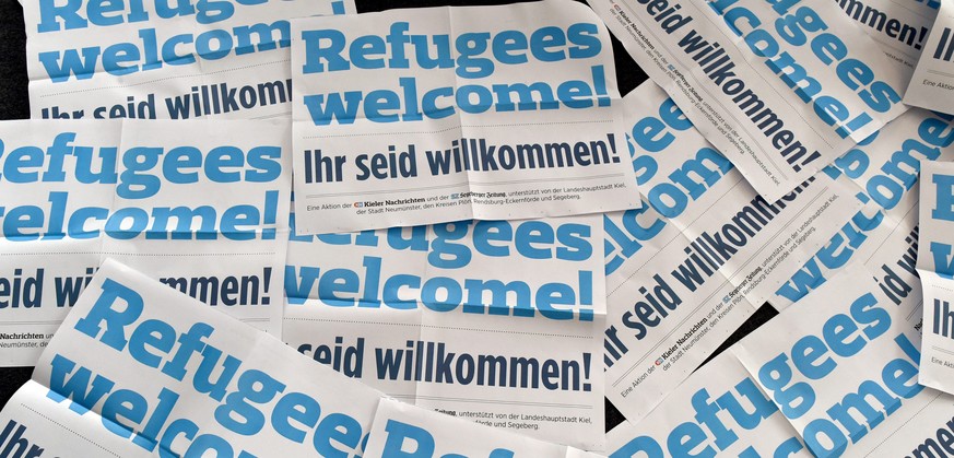 epa04912420 Christian Longardt, Editor in Chief of the &#039;Kieler Nachrichten&#039; newspaper, sits amid posters which read &#039;Refugees Welcome - you are welcome&#039; in Kiel, northern Germany,  ...