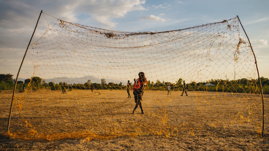 KENYA, RUSINGA, UTAJO - OCTOBER 22, 2016: african children playing football, near by Victoria Lake, Africa, sunset, editorial - Bilder