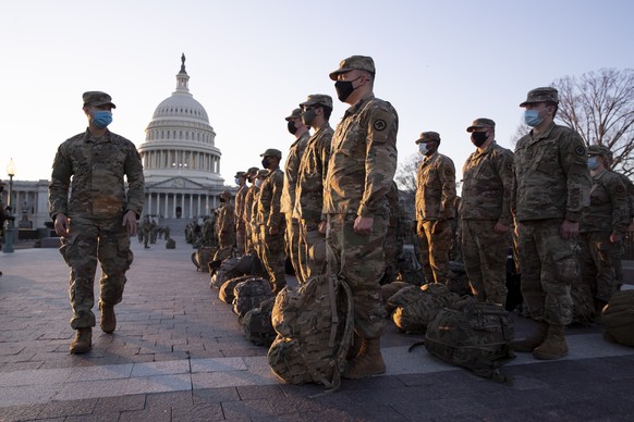 epa08933928 Members of the US National Guard gather on the grounds of the East Front of the US Capitol in Washington, DC, USA, 12 January 2021. At least ten thousand troops of the National Guard will  ...