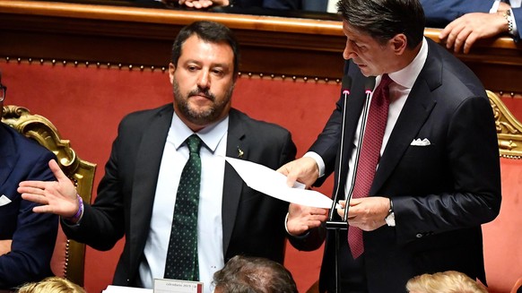 epa07782421 Italian Premier Giuseppe Conte (R) is flanked by Deputy Premier and Interior Minister Matteo Salvini (L) as he addresses the Senate over the government crisis in Rome, Italy, 20 August 201 ...