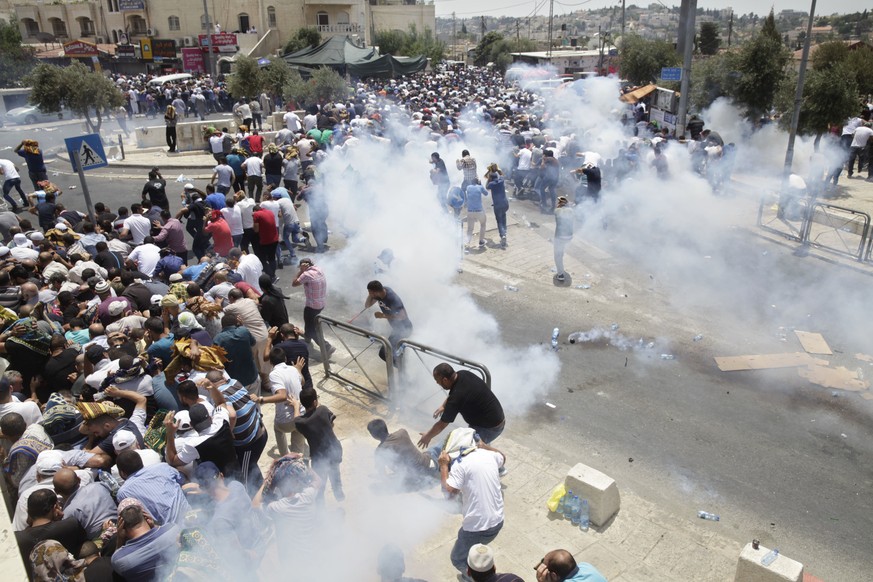 Palestinians run away from tear gas thrown by Israeli police officers outside Jerusalem&#039;s Old City, Friday, July 21, 2017. Israel police severely restricted Muslim access to a contested shrine in ...