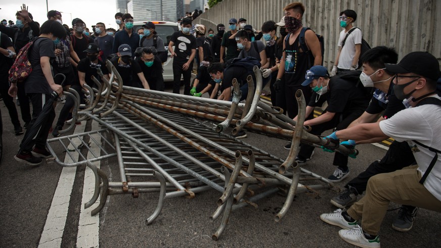 epa07642603 Protesters use barriers to build barricades during a rally against an extradition bill outside the Legislative Council in Hong Kong, China, 12 June 2019. The bill, scheduled for a second r ...