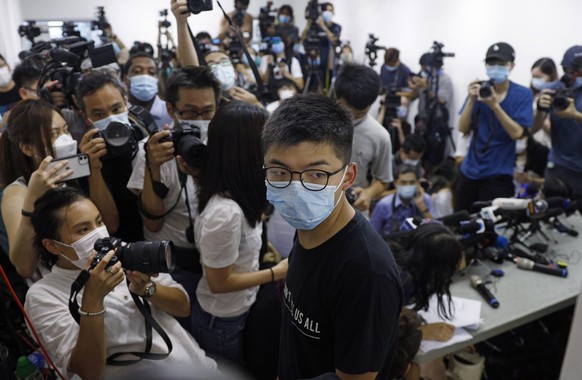 Hong Kong pro-democracy activist Joshua Wong, center, attends a press conference in Hong Kong, Friday, July 31, 2020. At least 12 Hong Kong pro-democracy nominees including prominent activist Joshua W ...