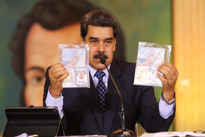 epa08406213 Handout photo made available by the Miraflores press of the Venezuelan President Nicolas Maduro showing the passports of the two Americans detained in Venezuela during a press conference h ...