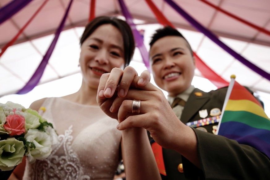 epa08784985 Couple Yi Wang (R) and Yumi Meng (L) pose for a photograph during a military mass wedding in Taoyuan, Taiwan, 30 October 2020. Two same sex couples tied the knot as part of a mass wedding  ...