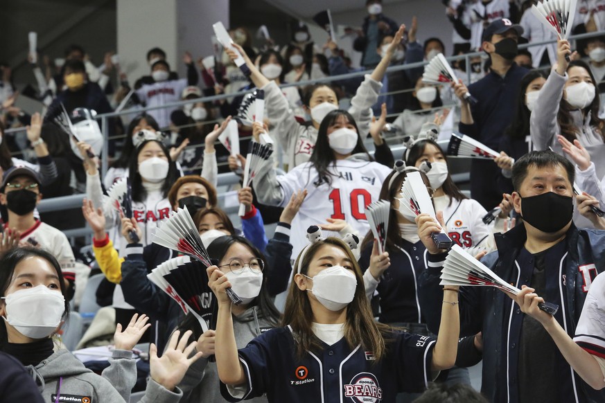 Fans wearing face masks as a precaution against the coronavirus cheer during the Game 4 of the Korean Series, the Korea Baseball Organization&#039;s championship round, between Doosan Bears and NC Din ...