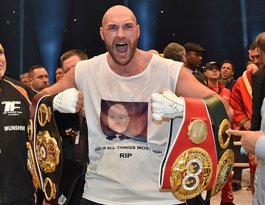 FILE - In this Nov. 29, 2015 file photo, Britain&#039;s new world champion Tyson Fury, celebrates with the WBA, IBF, WBO and IBO belts after winning the world heavyweight title fight against Ukraine&# ...