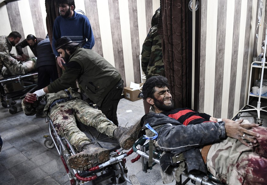 In this photo taken on Sunday, March 1, 2020, Turkey-backed opposition fighters carry fellow fighters for treatment who were wounded in fighting with Syrian government forces and their allies in Sarmi ...