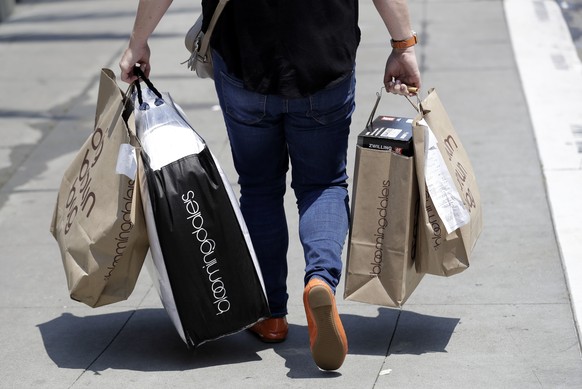 FILE- In this July 3, 2018, file photo, a shopper carries bags in San Francisco. Consumer confidence improved in May 2019, even as the stock market fell sharply amid escalating trade tensions between  ...