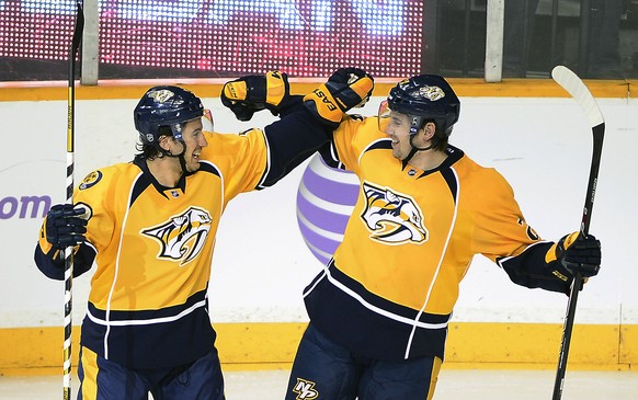 Nashville Predators defenseman Michael Del Zotto, left, celebrates with Simon Moser (5), of Switzerland, after Moser scored a goal in the third period of an NHL hockey game against the Winnipeg Jets o ...