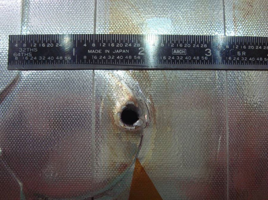 Orbiting debris hit Space Shuttle Endeavour’s radiator during one of its missions. The entry hole is about 6 millimeters (0.25 inches) across, and the exit hole is twice as large.